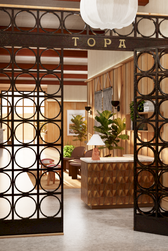 A stylish lobby or boutique entrance with circular-patterned iron doors, warm lighting, and a reception desk inside.