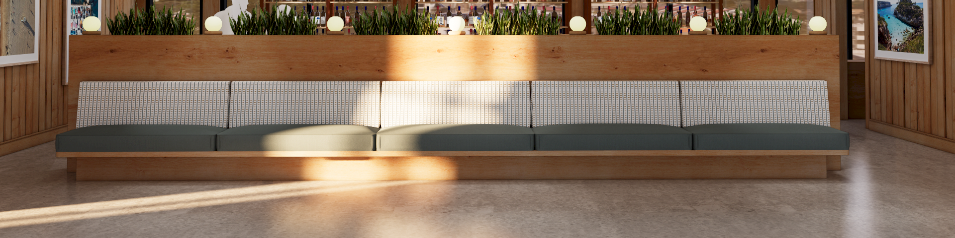 A sunlit, modern lounge with a long modular sofa, wooden walls, large windows behind, and decorative plants and pendant lights over a wooden divider.